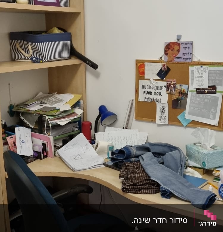 שולחן עבודה מבולגן עם ניירות, בגדים וכלי כתיבה